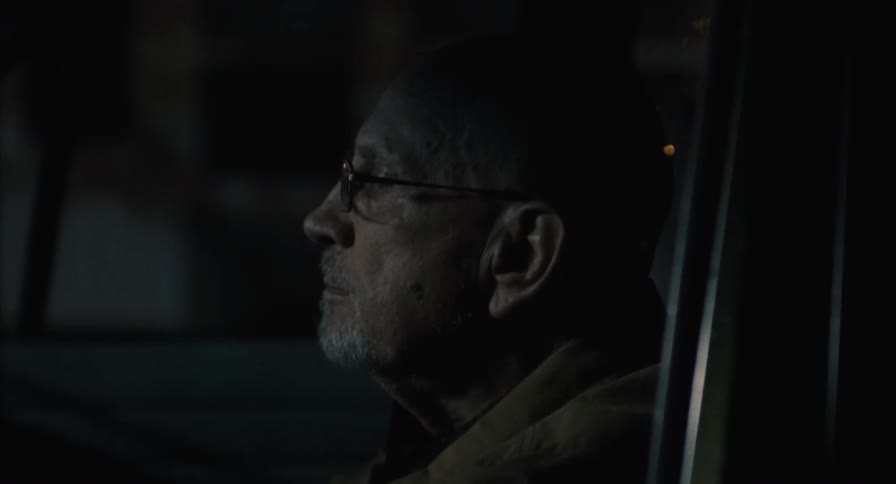 Contemplative man in car at night