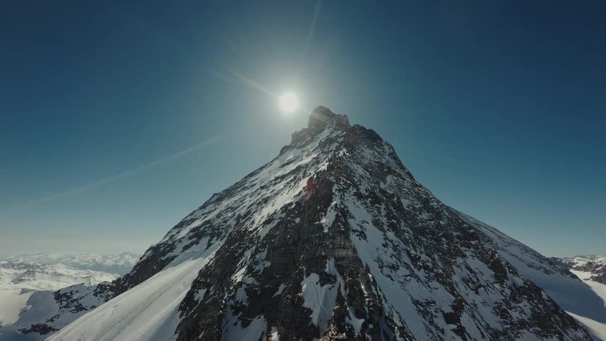 Snow is covering most of a mountain range on a sunny day