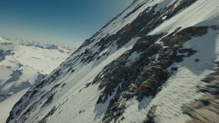 Steep mountain slope with exposed rocks and snow