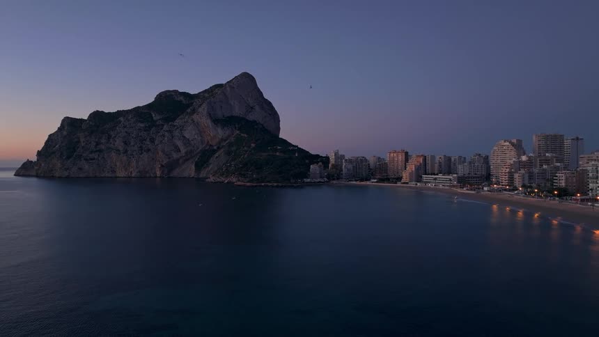 Buildings on the coast of the iberian peninsula with the rock of gibraltar overlooking seagulls flying over the sea