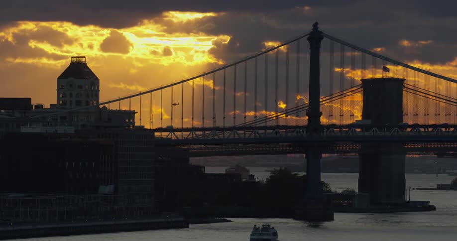 Cars cross a city bridge at sunset
