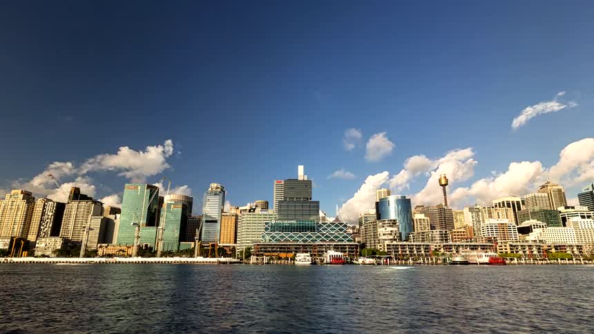 A time lapse shows clouds moving over the sydney skyline and harbor buildings