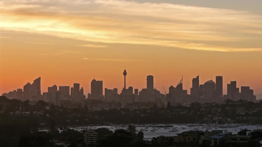 Golden evening illuminates high rise buildings across the city skyline