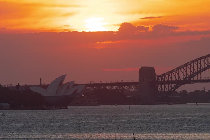 A time lapse of the sun setting over the sydney opera house