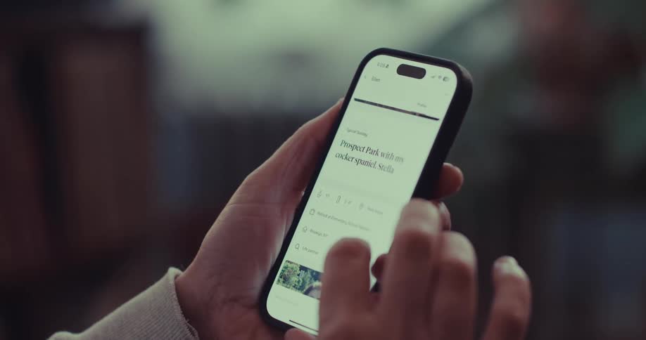 A man uses his thumb to scroll through a woman profile on a smartphone