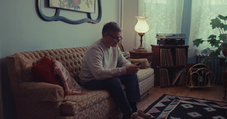 A man sitting on a couch using a smartphone