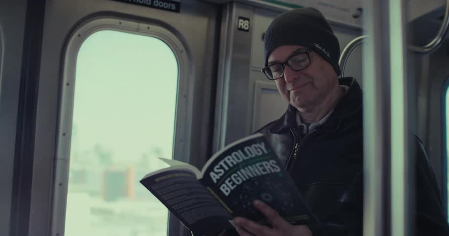 Man reads a book as he sits on a train