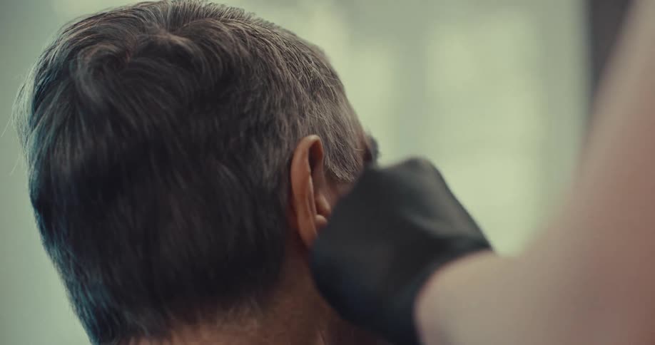 A man getting his hair cut at a barber shop