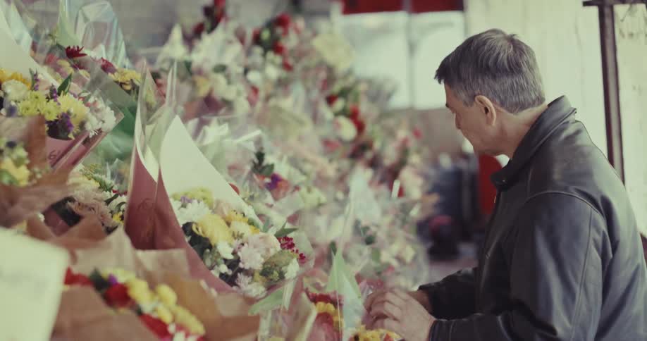 A man shopping for flowers at a stand