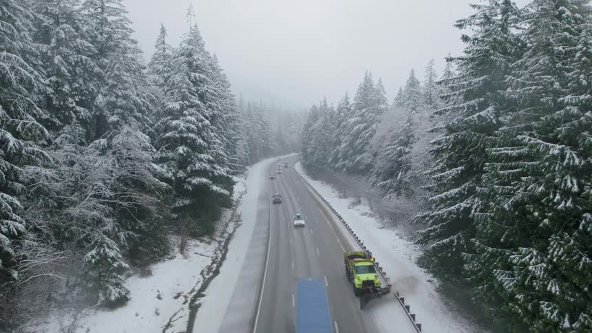 A snow plow works to keep the roadway clear for interstate traffic during a winter storm