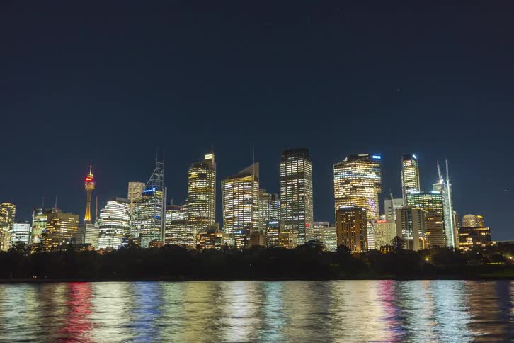 Illuminated skyscrapers reflected on the water at night