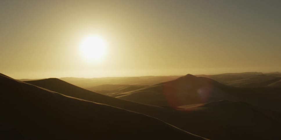 Sun illuminates vast dunes on the desert horizon