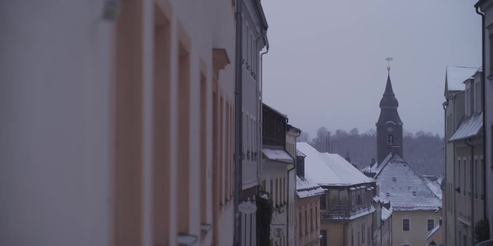 Snow covers the roofs of several building located next to each other