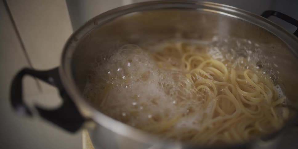 Pasta cooking in pot with boiling water