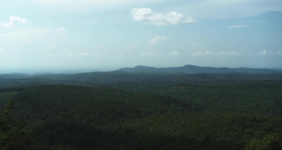 Forested mountain with trees covering the slope and forests fill the valley with mountains across the landscape