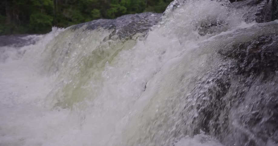 Water splashes as a waterfall flows over a cliff