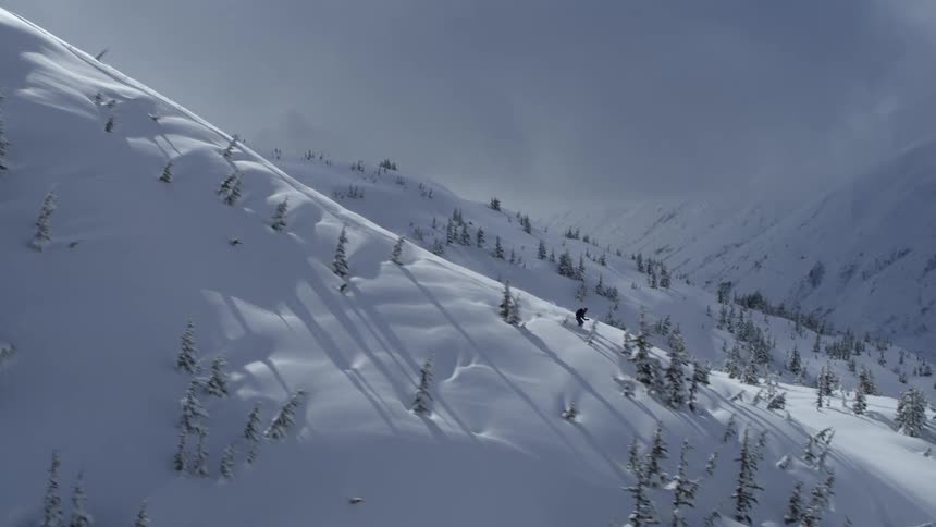 Skier slides down a snow covered mountain slope