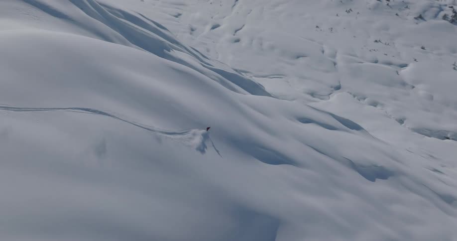 Skier slides down a snow covered mountain slope