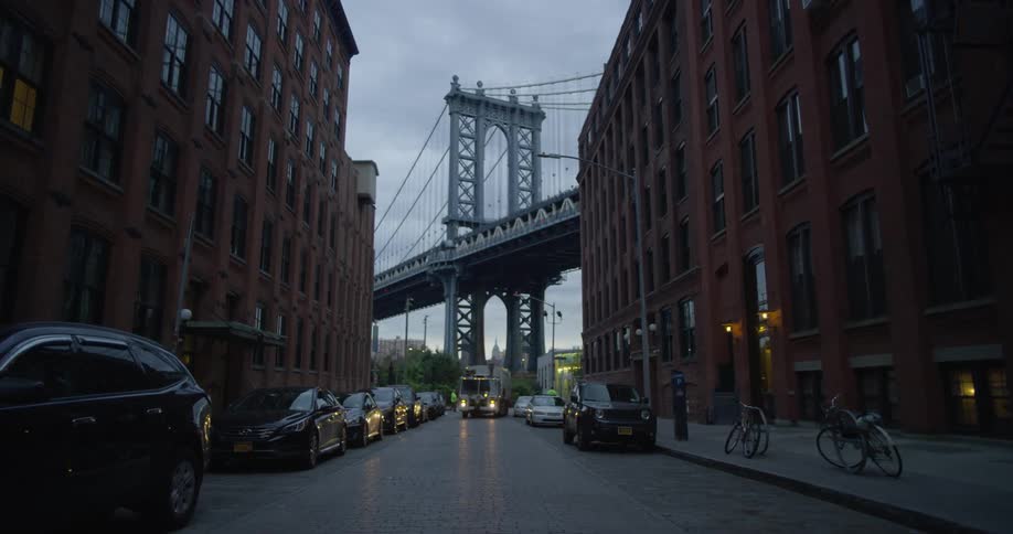 A garbage truck is at the end of this city block
