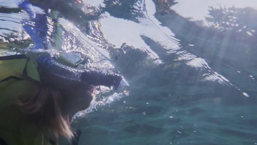 A scuba diver swims towards the surface