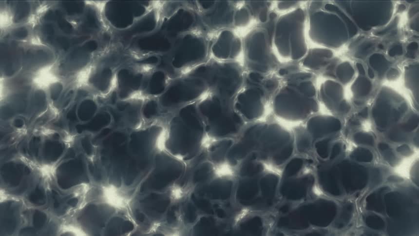 A dark, glowing, and abstract organic matter with a grainy texture moves in slow motion