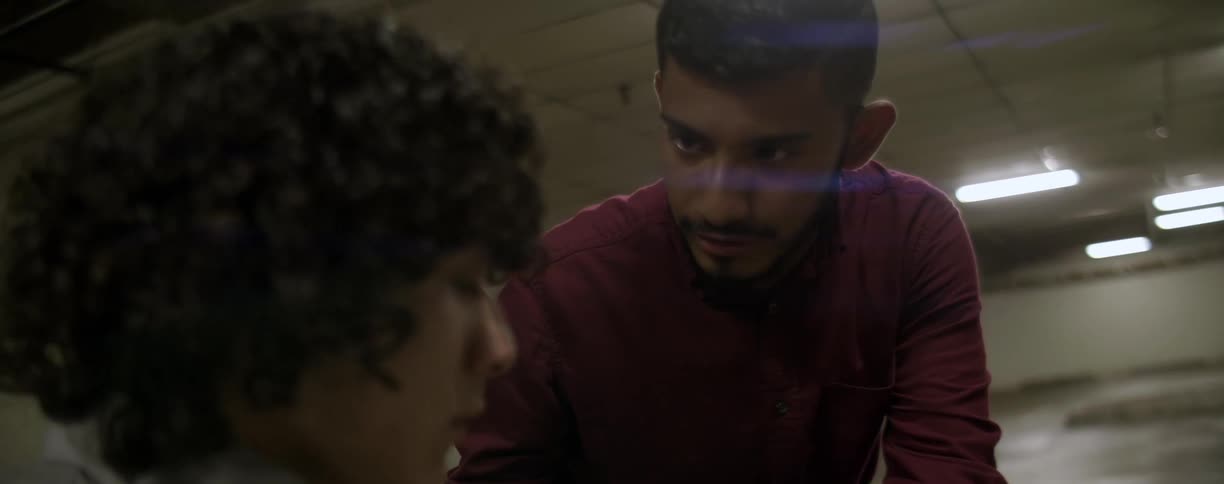 Two men talk in a parking garage