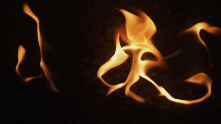 Flames dance around slowly in the dark
