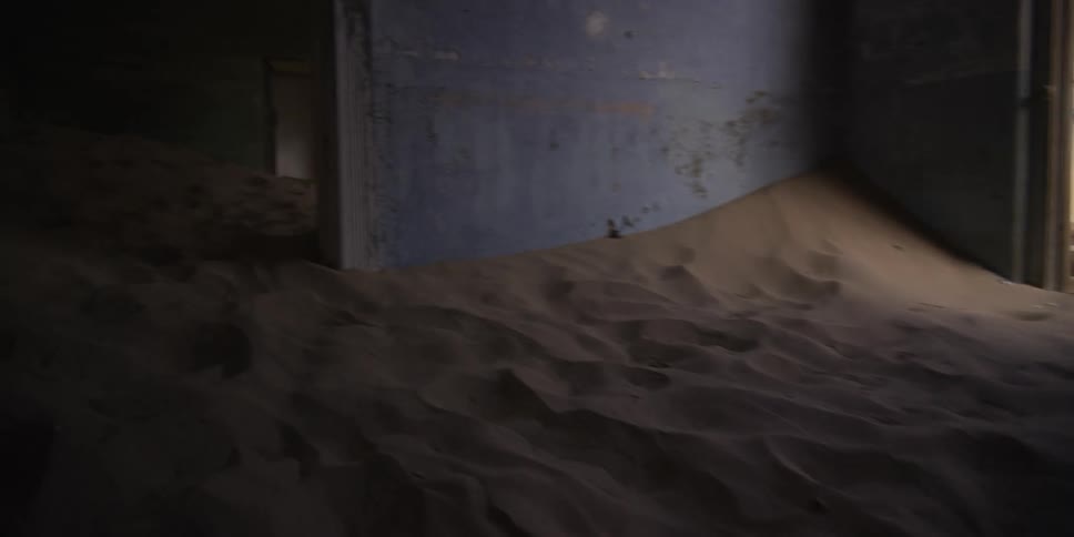 Sand from the surrounding desert slowly drifts in and fills the rooms of a derelict and abandoned building
