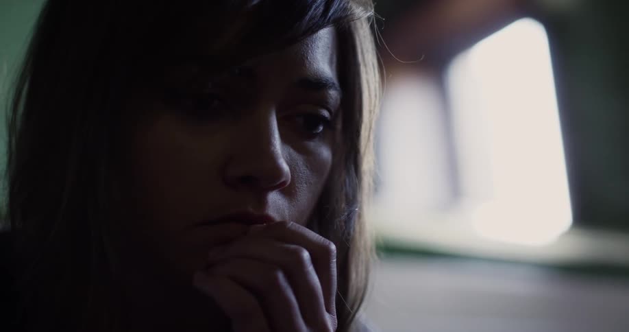 A woman touches her face looking worried