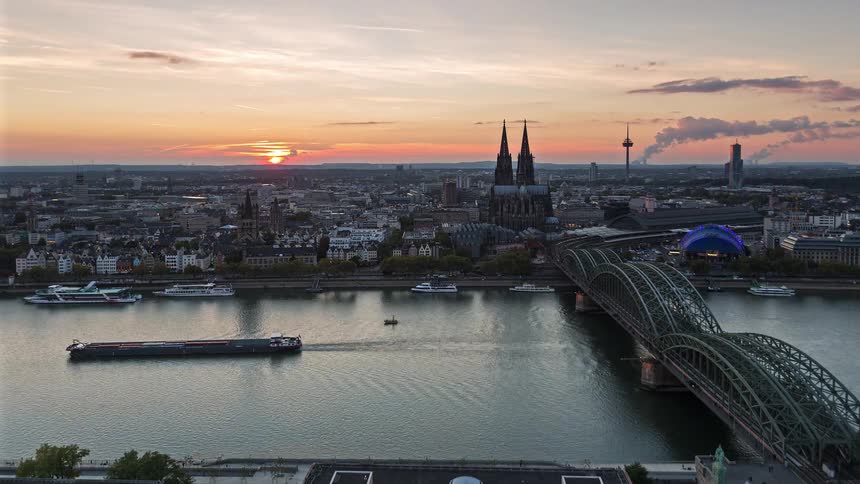 A stunning day-to-night time-lapse of Cologne, Germany, featuring the iconic Cathedral and Hohenzollern Bridge as the sun sets over the Rhine River