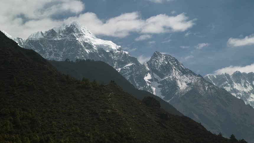 The high mountains are covered with trees and snow