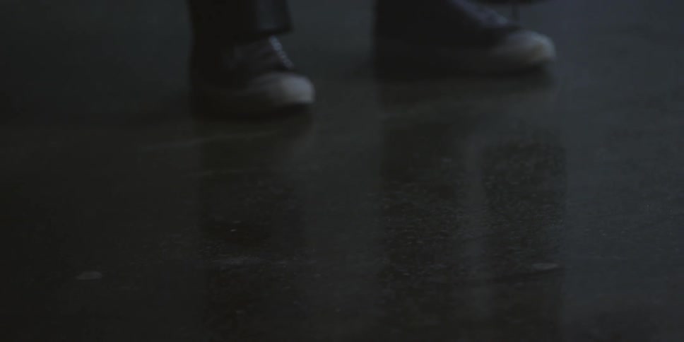 A person is standing on a dark floor