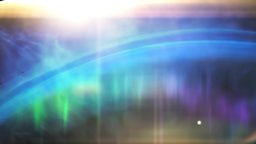 A stylized animation shows a vibrant aurora dancing across a planet's atmosphere with a bright sun flare