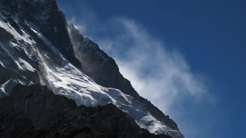 Snow on mountain cliffs on cloudy day