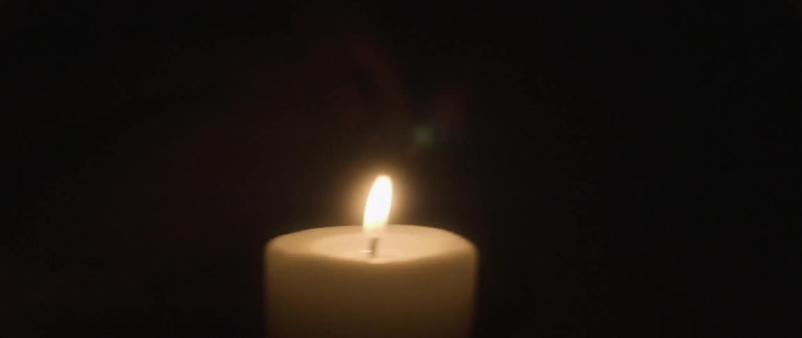 The candle is flickering in the dark room