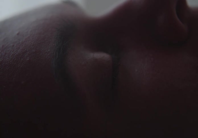 Extreme close-up of a person's eye slowly opening and closing in the dark