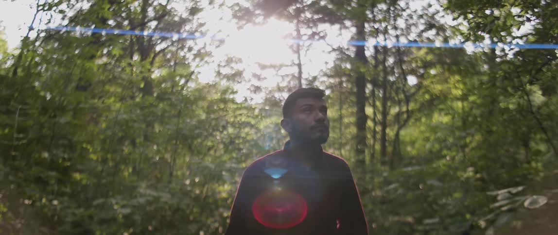 Man walks through the woods looking around
