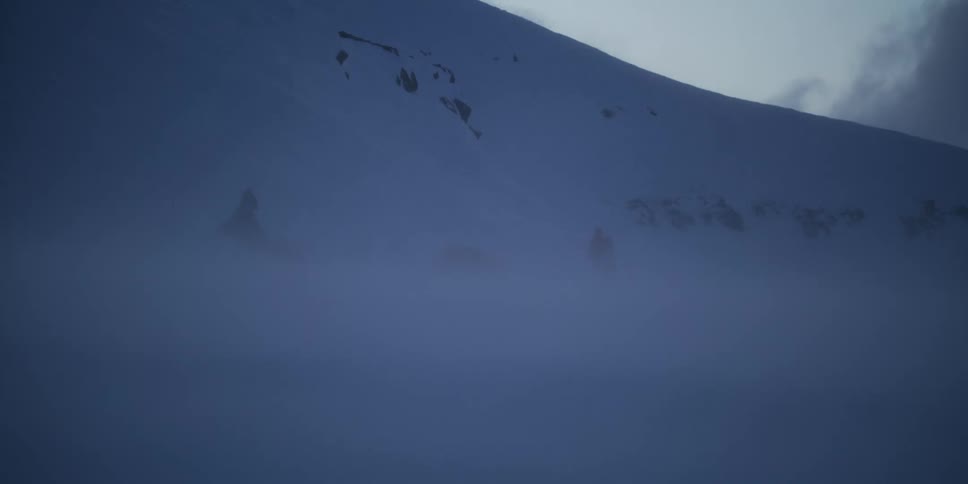 An explorer braves a fierce blizzard, standing by a tent and snowmobile on a desolate, snow-covered mountain