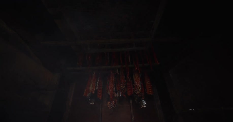 Fresh salmon fillets hang on wooden racks, curing in a dark and smoky traditional smokehouse