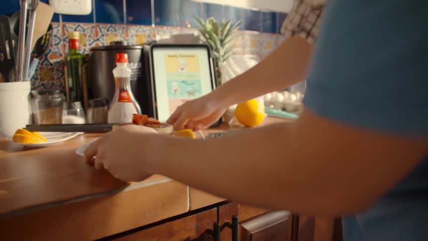 A person takes a photo of homemade pancakes with a smartphone before carrying the plate away from the kitchen