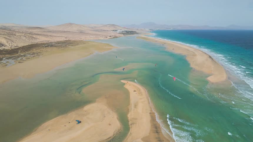 Stunning aerial time-lapse shows the tide flooding a vast desert beach to create a turquoise lagoon, a popular spot for kitesurfing