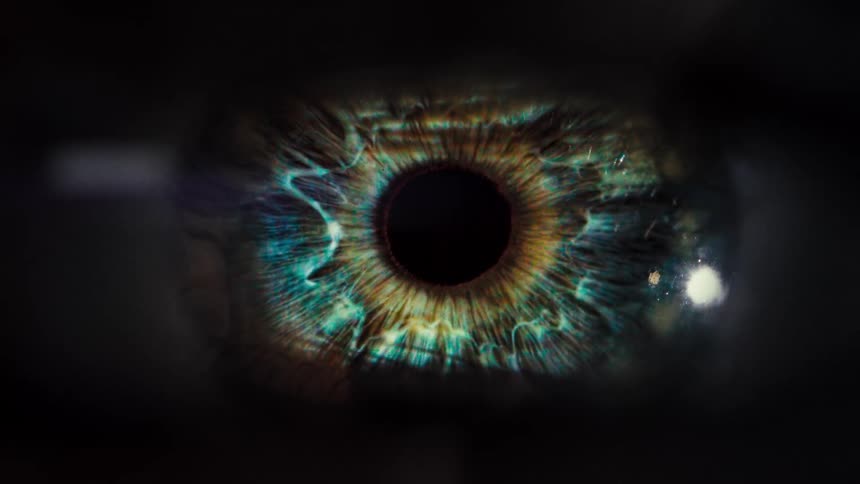 A beautiful and colorful human eye is revealed in a slow and dramatic macro shot