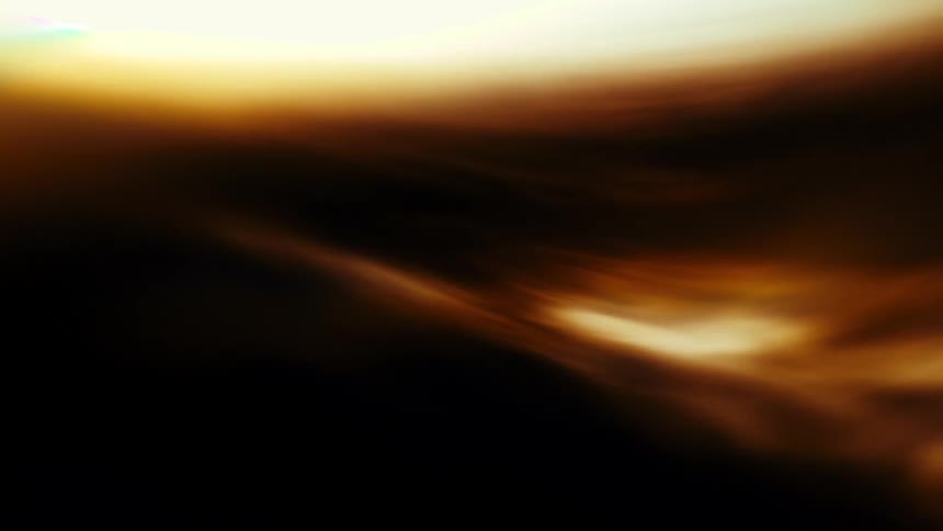Ethereal golden light and shadows drift and flow gracefully across a dark void