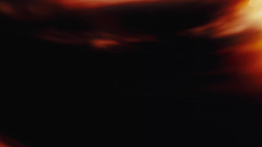 Soft, glowing orange light leaks and film burns create a warm, vintage abstract background
