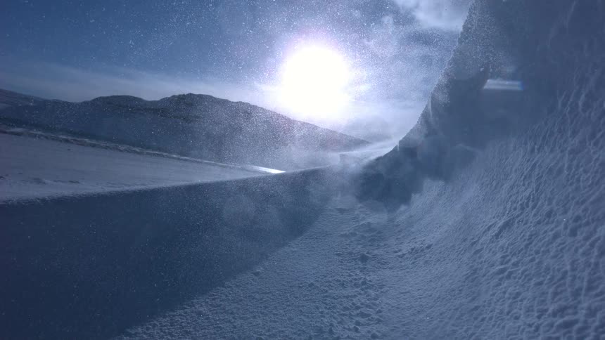 Seamless loop of a fierce arctic blizzard with wind-blown snow glistening in the bright sun