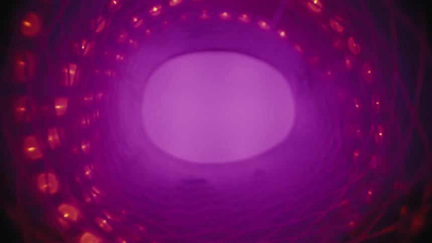 An abstract, futuristic view from inside a swirling vortex of red and purple glowing lights