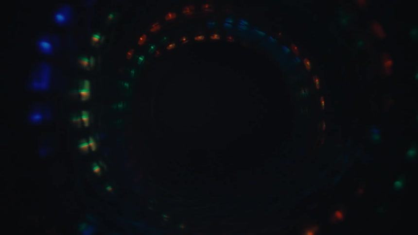 An abstract point-of-view journey through a spiraling vortex of flashing multicolored lights