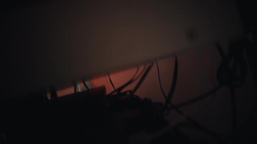 A shaky first-person perspective navigates through a dark and claustrophobic space filled with tangled electronic wires