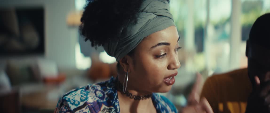 A close-up of a stylish young Black woman having an expressive and emotional conversation indoors