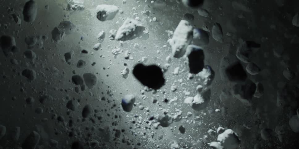 A dramatic slow-motion pull-back reveals a mysterious landscape of white rocks and powder